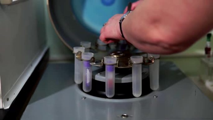 实验室工作人员将试管插入生化分析仪中