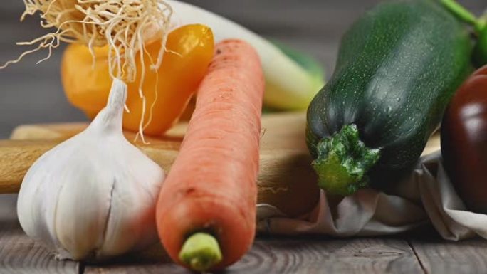 各种美味健康有机蔬菜的静物，在质朴的木桌上。焦点从背景转移到前景。