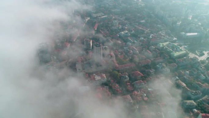 鸟瞰图的大城市景观，上面笼罩着浓雾，醒来，日出时从上方的大城市，晨雾