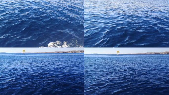在沙姆沙伊赫 (埃及) 的红海表面快速移动和一艘带降落伞的船在远处 (13)