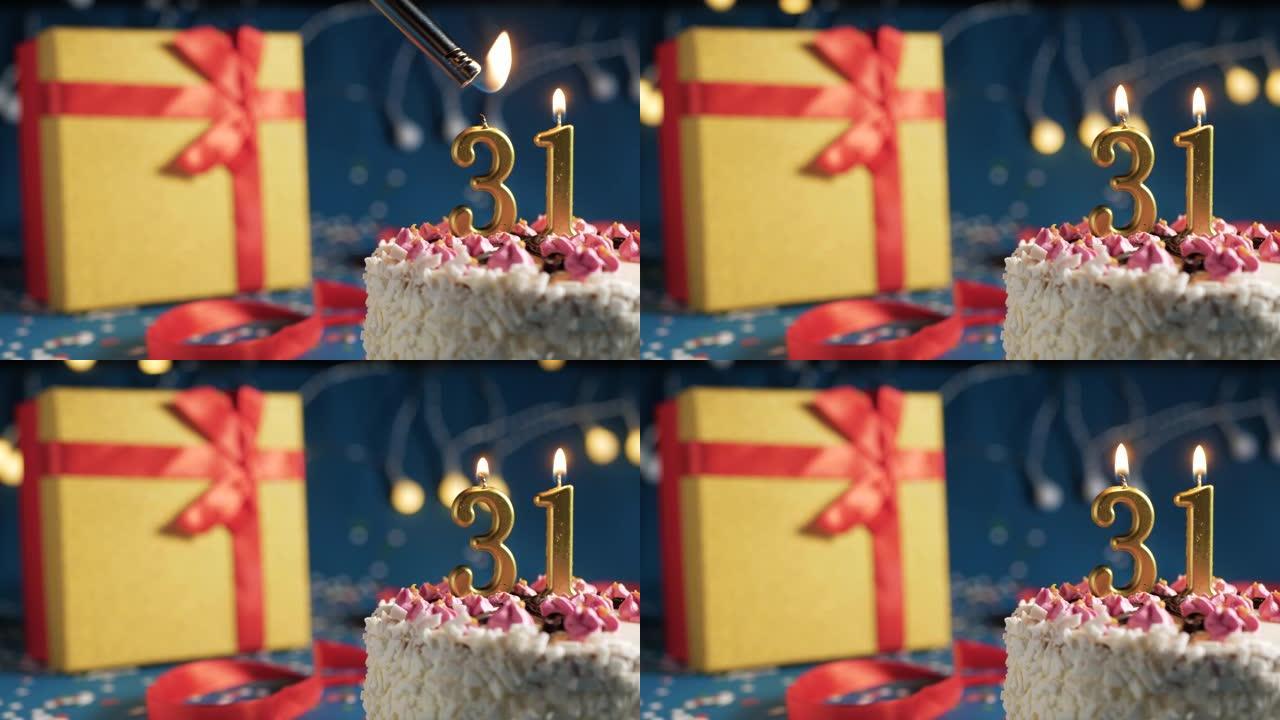白色生日蛋糕编号31点灯燃烧的金色蜡烛，带灯的蓝色背景和用红丝带绑起来的礼物黄色盒子。特写