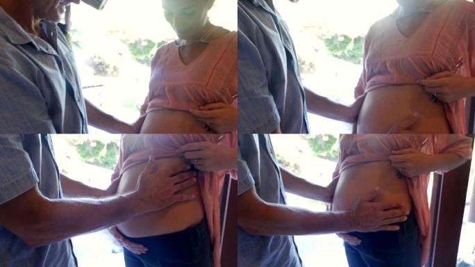 倾斜孕妇和男人触摸未出生的婴儿