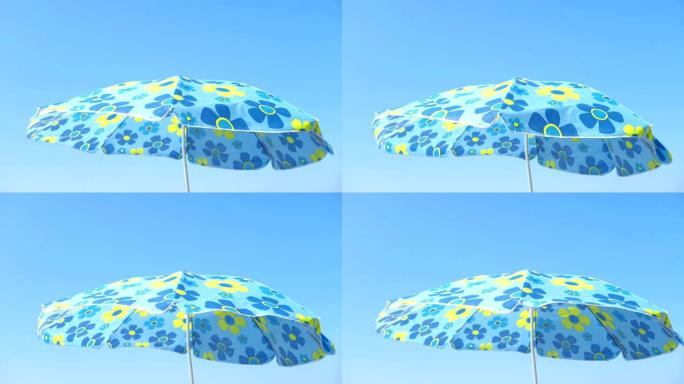 遮阳伞在蓝天下在沙滩上轻风移动
