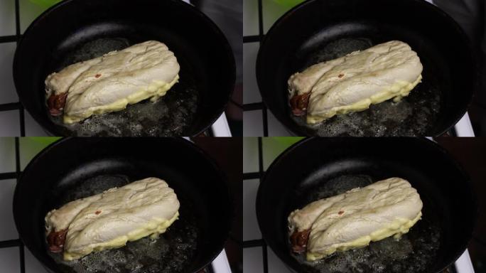 在加热的黄油煎锅中，将鸡柳卷油炸。你可以看到油是如何沸腾的。