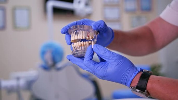 医生显示在一个塑料颚样本或模型不同的牙齿治疗方法。