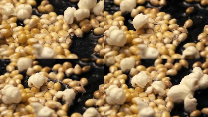 玉米种子在煎锅中弹出，并带有一些油慢动作镜头。
