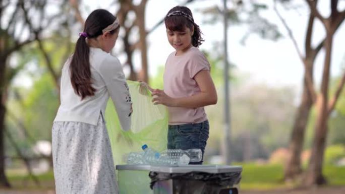 女孩和朋友帮助清理并将纸张扔进垃圾箱，捡起或垃圾收集地面上的垃圾