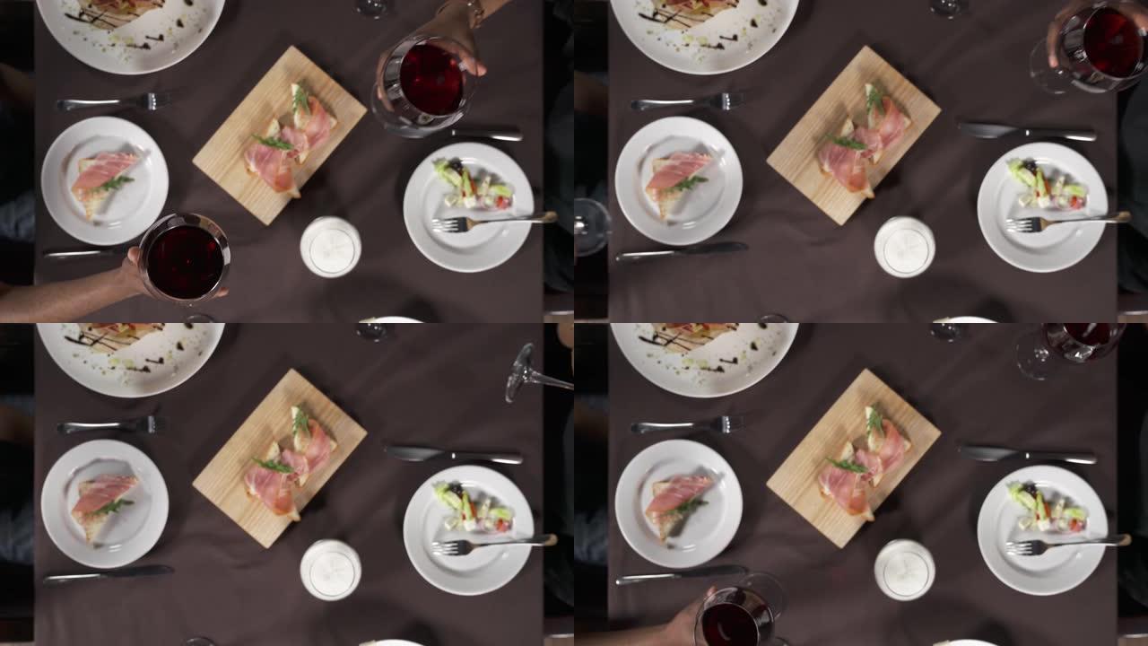 一对非洲裔美国夫妇在餐厅吃晚饭时喝酒的俯视图。休闲，食物，饮料，人的概念