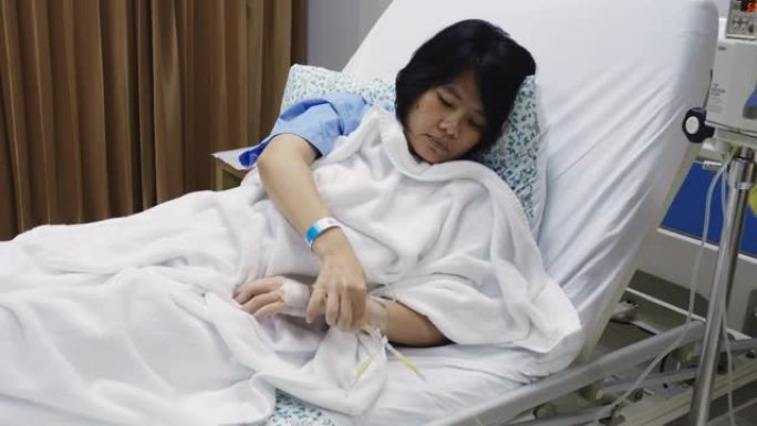 亚洲妇女咳嗽和病人床上戴着口罩。