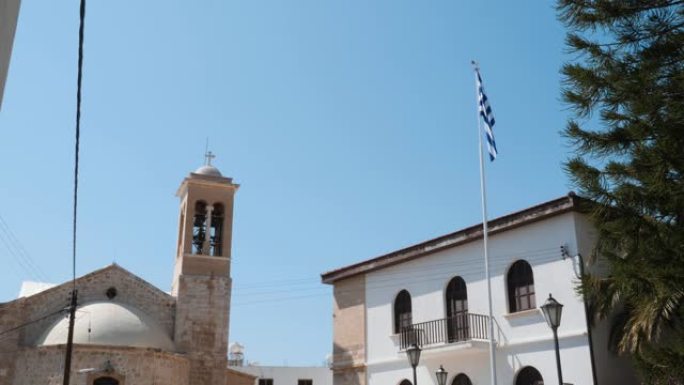 高旗旗杆上的希腊国旗的美丽景色，背景是教堂
