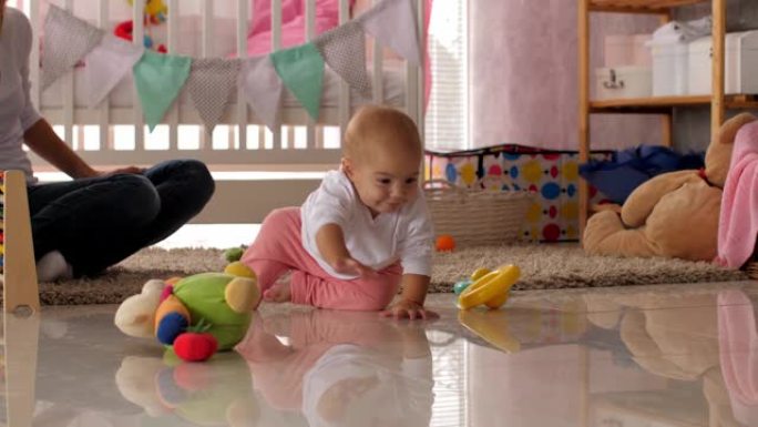 女婴在托儿所里爬行，玩玩具