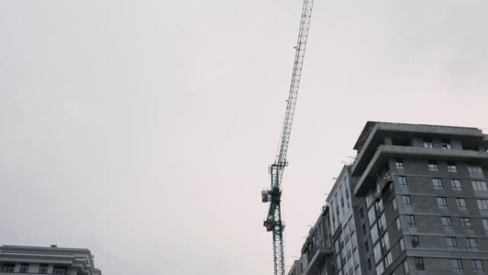 建筑起重机在建筑工地工作。正在建设中的高层住宅综合体。绿区公寓楼建设。正在建造的摩天大楼，带有巨大的