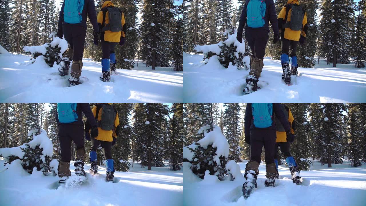 慢动作手持移动拍摄成人徒步旅行者的脚在户外深雪中离开相机雪鞋行走