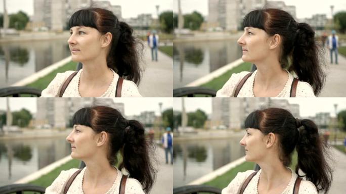 敏感女游客的特写肖像正看着相机微笑。在德国柏林的大街上，漂亮脸蛋的迷人女孩在镜头前愉快地微笑着。城市