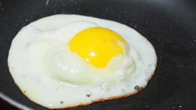 特写在一个小煎锅里煮鸡蛋。准备早餐