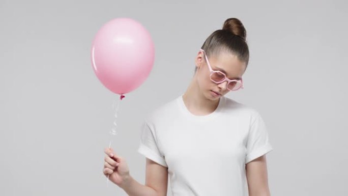 糟糕的生日。粉红色气球的年轻女孩，派对后心情不好
