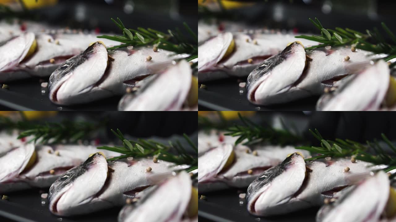 厨师将迷迭香小枝放在新鲜的鱼上，慢动作。健康食品的概念。