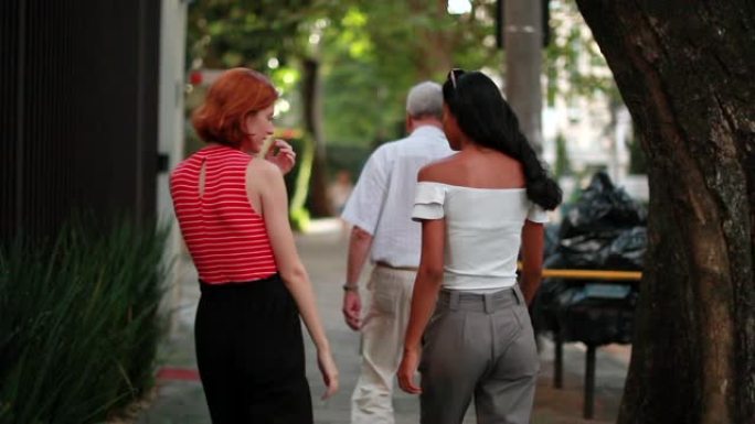 两个女性朋友走在人行道上