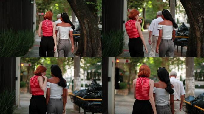 两个女性朋友走在人行道上