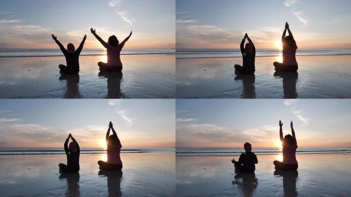 亚洲家庭母子在日落时在沙滩上练习瑜伽。健康运动慢动作