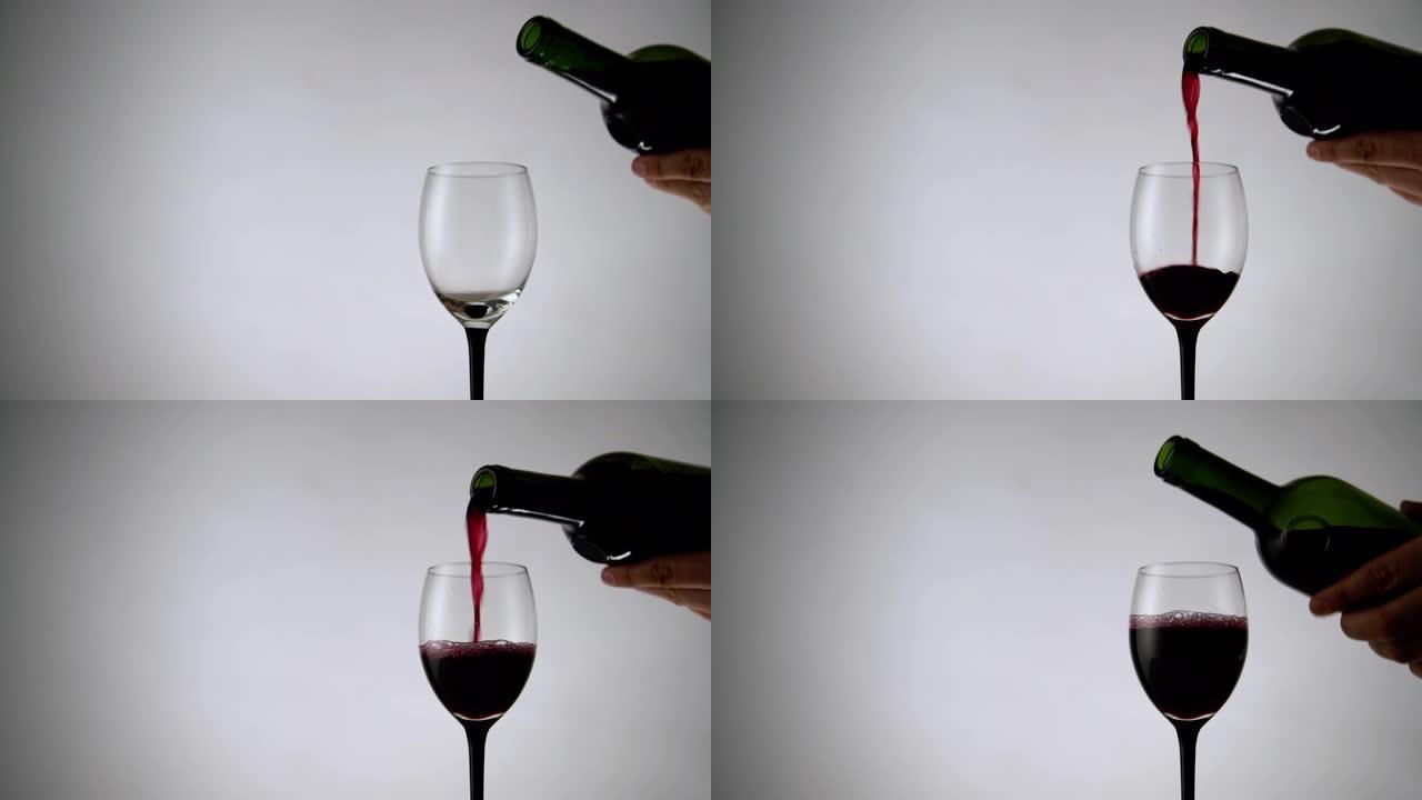 将红酒倒入白色背景的玻璃杯中。淡淡的背景下充满酒精饮料的酒杯