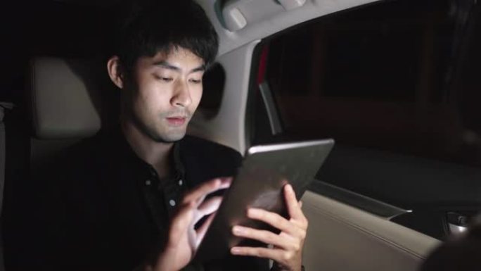 夜间年轻人在汽车旅行时使用笔记本电脑