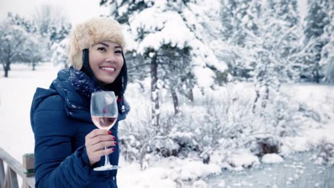 东南亚女人喝着酒，冬天在白雪皑皑的森林里