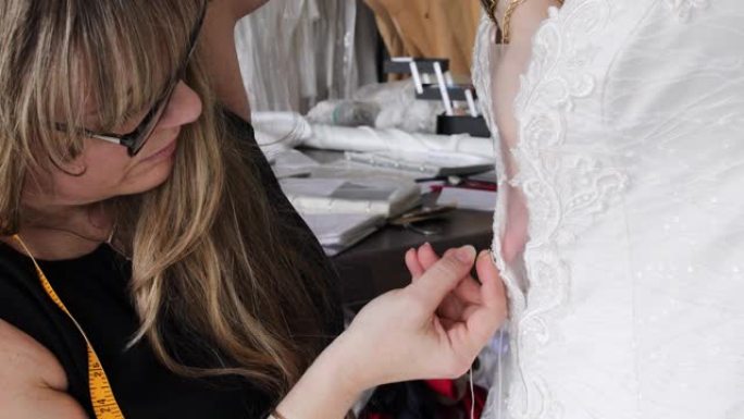 时装设计师在婚纱上进行精致的手工缝制