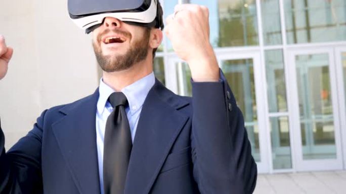 男子在虚拟现实体验中庆祝胜利，户外使用VR耳机