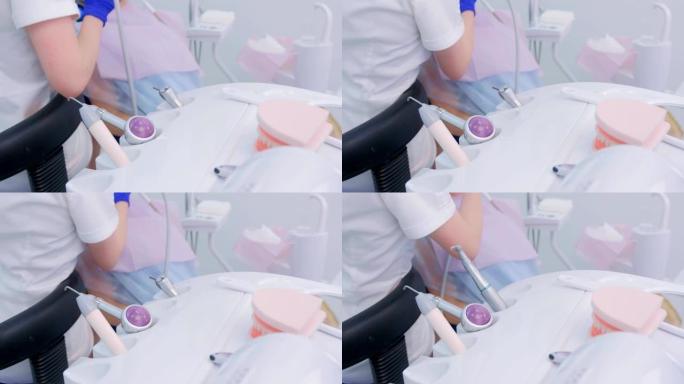 女牙医使用医疗设备钻牙科手的刷子特写。
