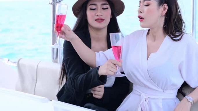 美丽的女孩朋友在豪华生活方式的海洋帆船上享受葡萄酒快乐冒险旅行假期