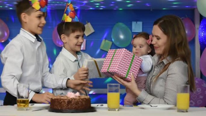 两个男孩祝贺妈妈和宝宝的生日并赠送礼物