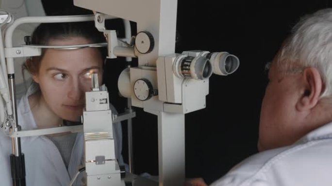 用裂隙灯进行眼科检查。年轻女子在眼科医生那里检查眼睛。白领工人。活跃的老年人在他们的工作场所。