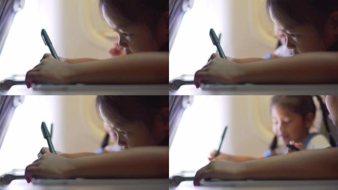 特写镜头，亚洲儿童女孩在飞行中画画和看书。