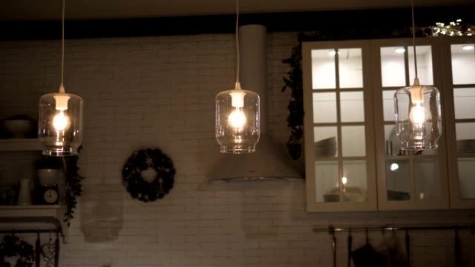 桌子上方的厨房里用玻璃罐制成的现代时尚灯具。