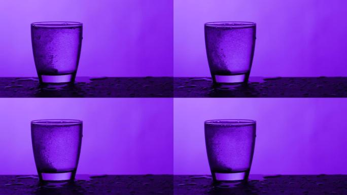 泡腾片滴入一杯水-紫色背景，慢动作