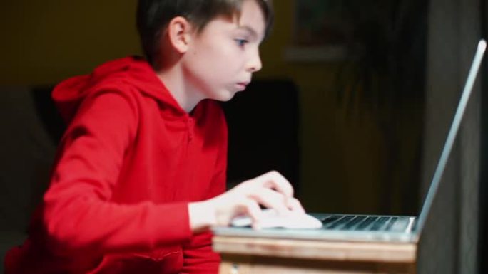 晚上，一个男生在房间里用笔记本电脑玩耍。