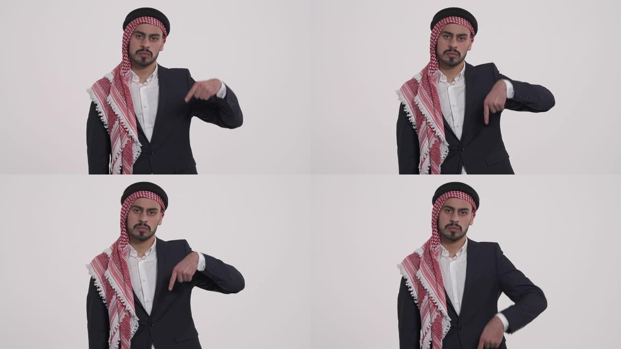 沙特族裔的阿拉伯人对表达负面情绪感到失望。面部表情。男人用食指朝下。孤立，在白色背景上