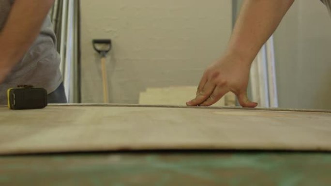 木匠使用卷尺标记胶合板的截面