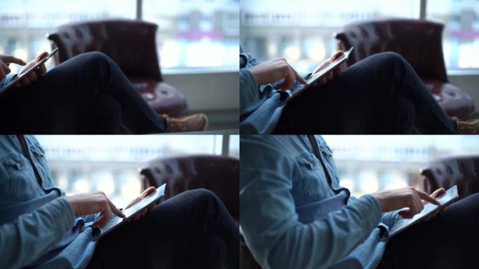 一个yuoung商人使用平板电脑坐在办公室的椅子上的特写镜头。