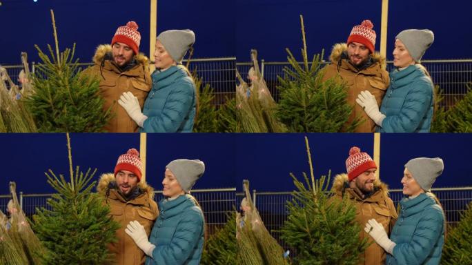 幸福的夫妇在市场上购买圣诞树