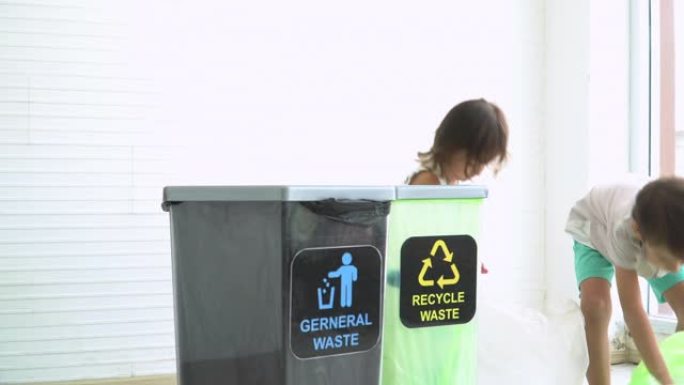 看不到兄弟姐妹帮助将塑料瓶分离成可回收垃圾箱