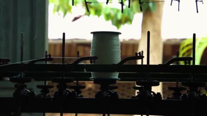 将丝绸纤维纺成线，然后将丝绸编织成纺织品。村工厂手工制作的生丝。