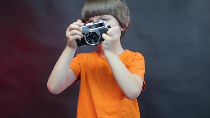 一个嘴巴密封的男孩手里拿着相机。