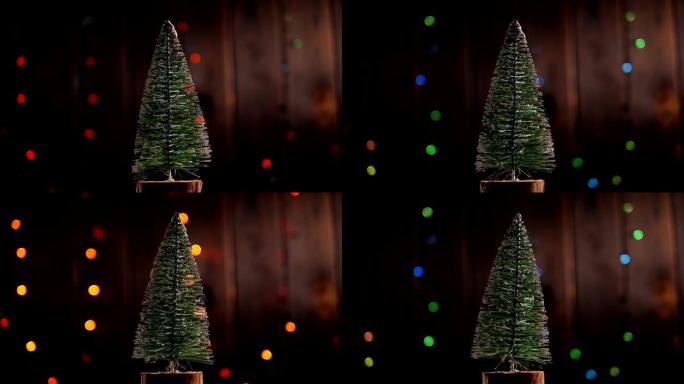 圣诞树在闪烁的灯光下在木制背景上缓慢旋转。