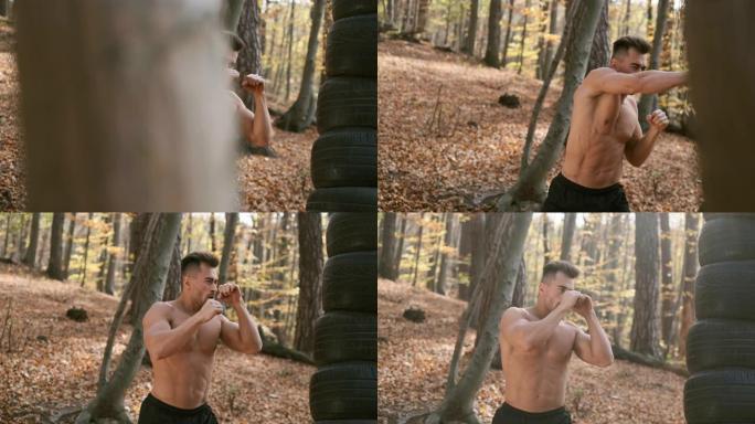 强壮裸躯干的家伙使拳击与他的手。秋天的森林。
