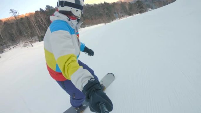 一名男子骑着滑雪板沿着滑雪坡行驶。冬季娱乐概念。慢动作镜头