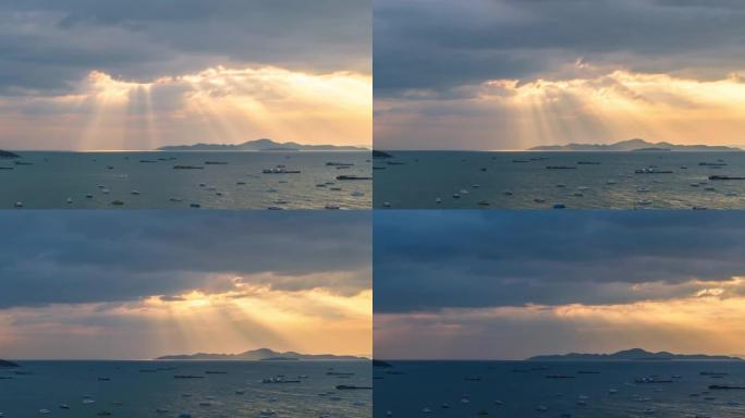 晚上日落时分令人惊叹的场景。海上的船。金光穿越云层到山海，泰国春武里府