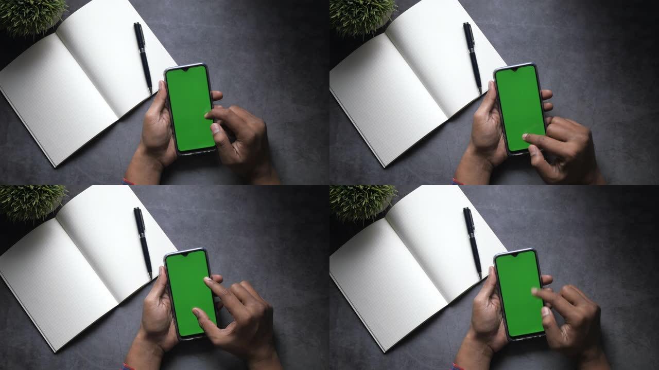 使用绿屏智能手机的人手俯视图