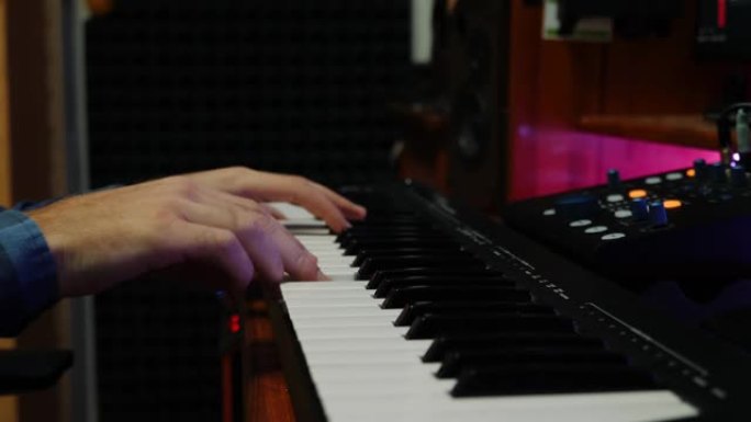 手指在录音棚里弹钢琴midi键盘。手在数字音频工作站中弹钢琴和创作歌曲。音乐创作过程。音乐家演奏钢琴